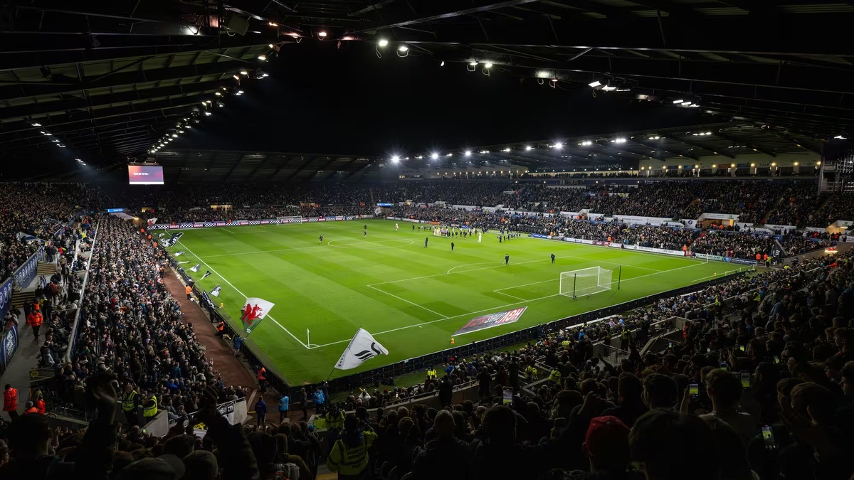 A packed Swansea.com Stadium under floodlights as the teams walk out for Swansea City's match against Manchester City in October 2025