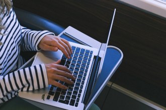 A person working on a laptop at a train table during a journey