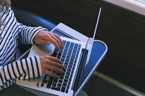 A person working on a laptop at a train table during a journey