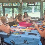 Children and adults making crafts around a table at Underhill Hub in Mumbles