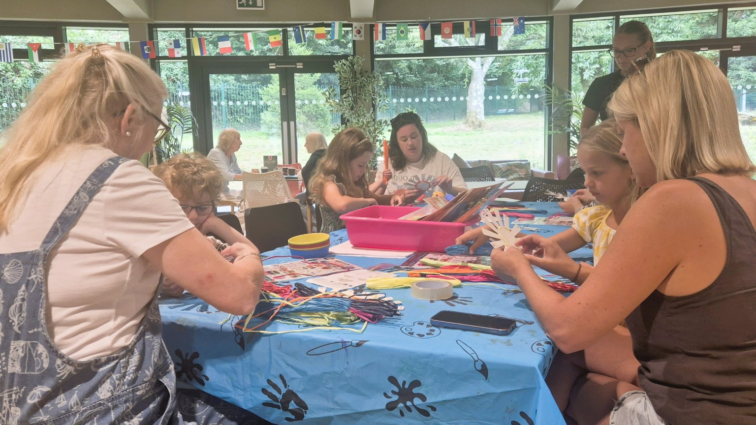 Children and adults making crafts around a table at Underhill Hub in Mumbles
