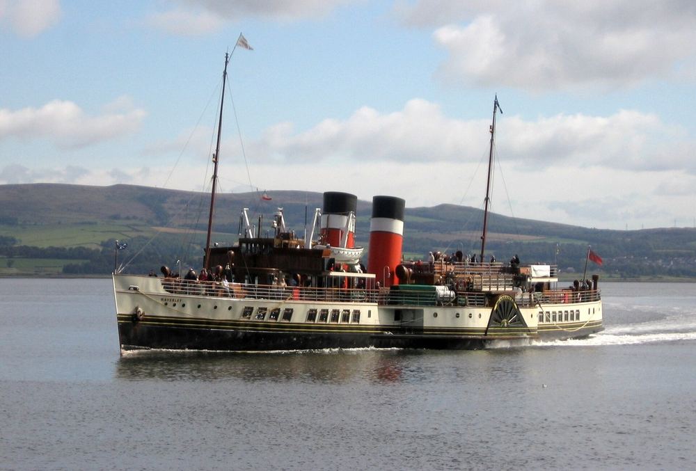 The paddle steamer Waverley under way with passengers on deck and hills behind