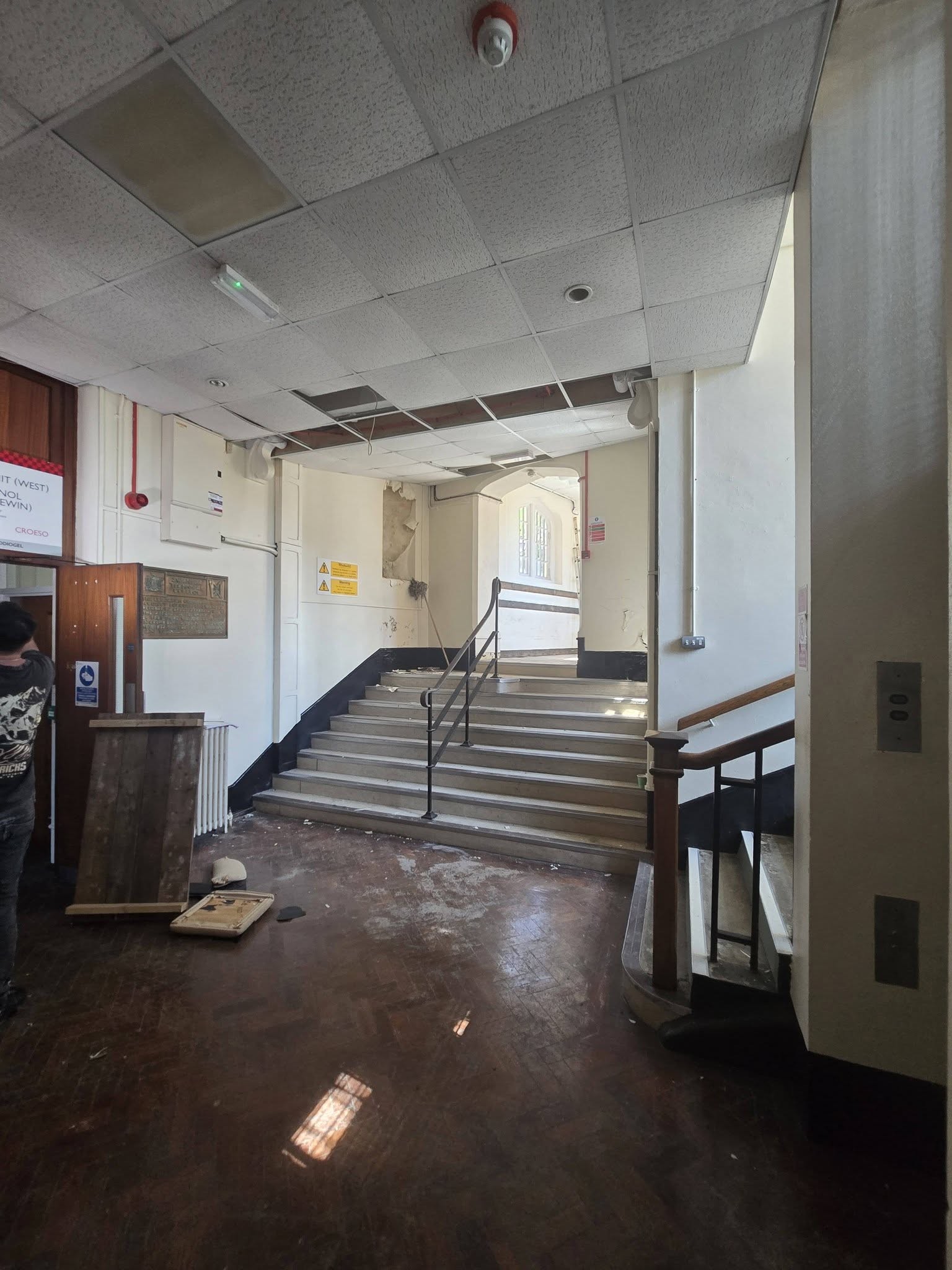 Entrance hall with parquet floor stone steps and scattered debris