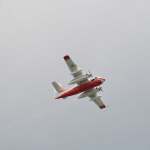 A red and white Grumman Firecat water bomber in French Sécurité Civile markings banking over Swansea Bay
