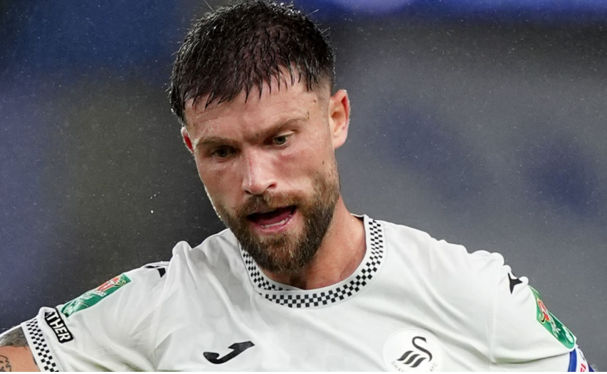 Swansea City defender Cameron Burgess in a white home shirt during a match