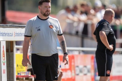 Pure Swansea manager Jack Midwinter watching from the touchline in a white training top