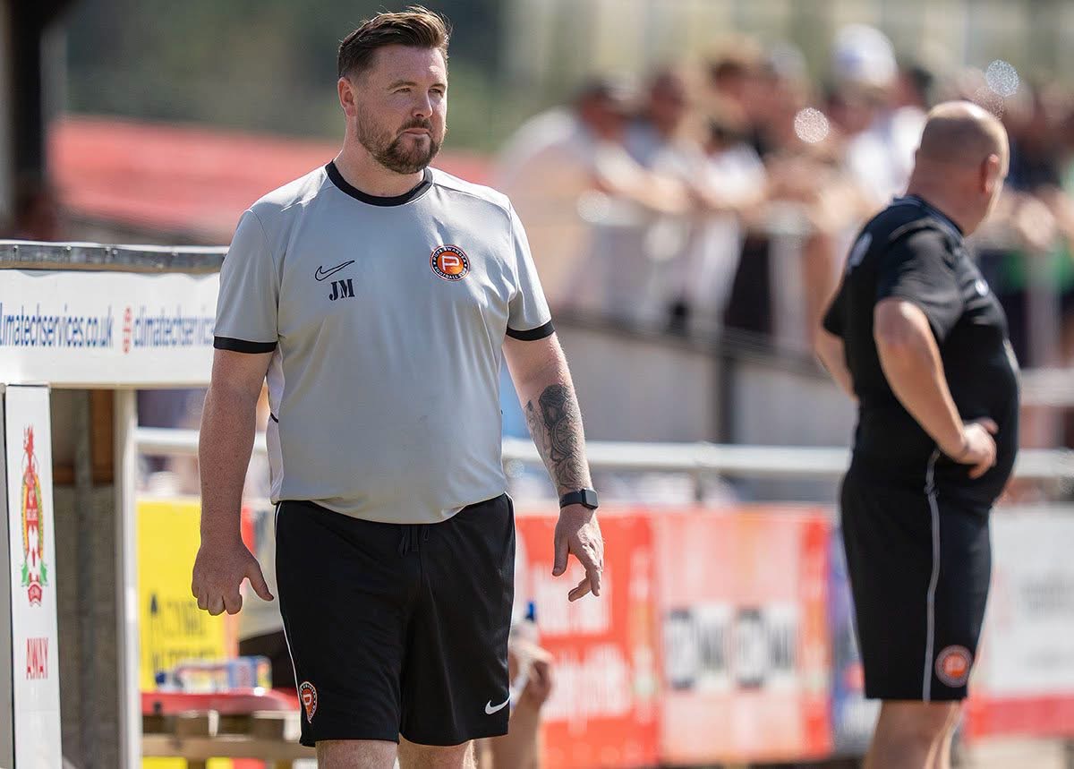 Pure Swansea manager Jack Midwinter watching from the touchline in a white training top