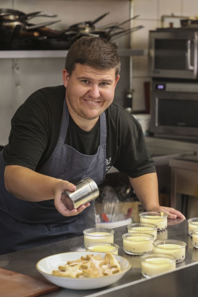 Aaron Jones dusting sugar over desserts in the Penycae Inn kitchen
