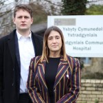 David Chadwick MP and Jane Dodds MS standing in front of the bilingual Ystradgynlais Community Hospital sign