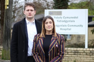 David Chadwick MP and Jane Dodds MS standing in front of the bilingual Ystradgynlais Community Hospital sign