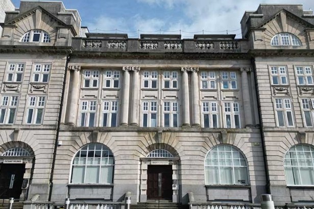 The stone front elevation of the Grade II listed Exchange Buildings on Adelaide Street in Swansea