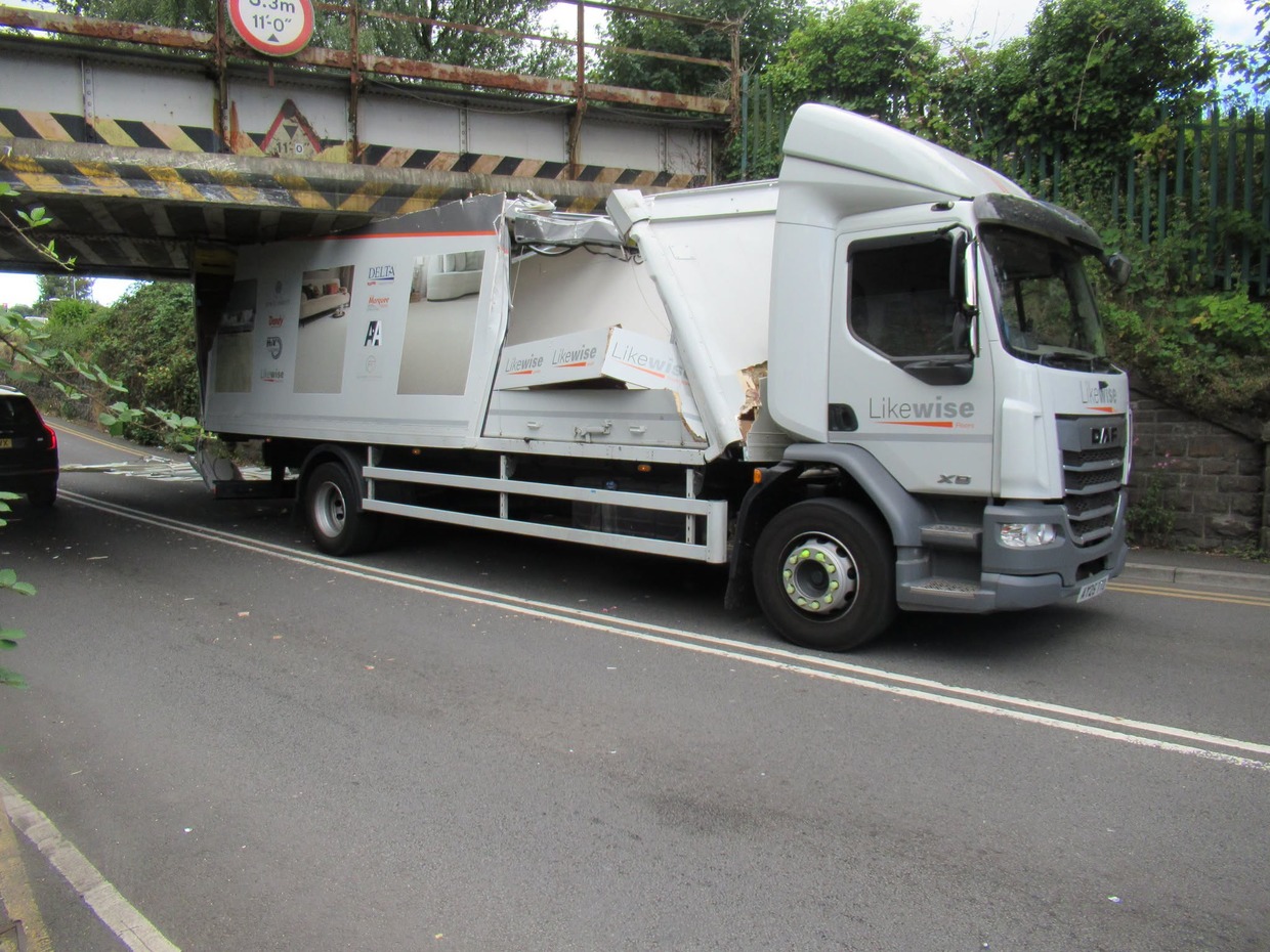 A Likewise Floors lorry with its roof torn open wedged under the Trafle Mill railway bridge in Gowerton