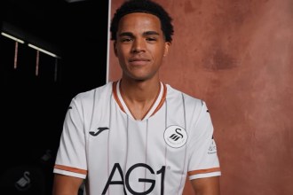 Tom Iorpenda facing the camera in the Swansea City home shirt at his signing photo shoot