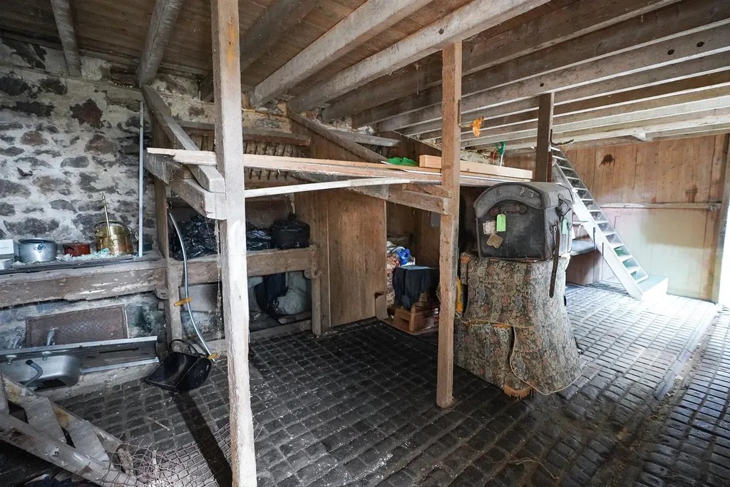 Inside a stone barn with timber stalls, a cobbled floor and a copper on a stand