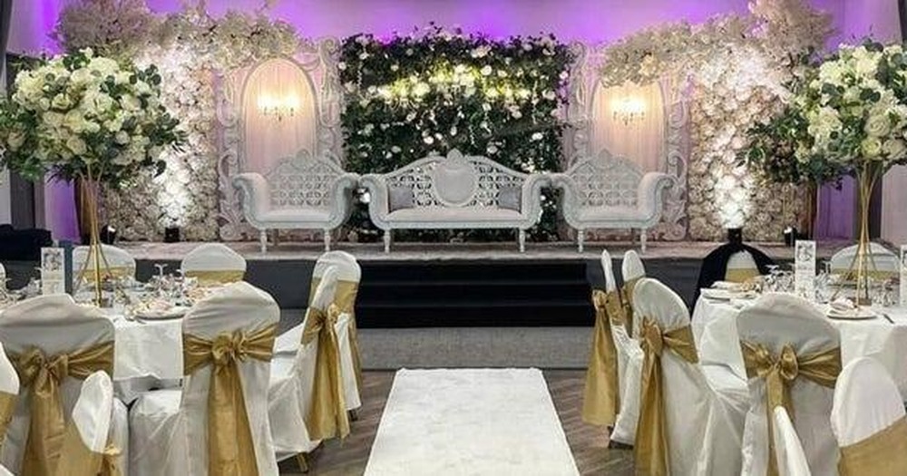 A wedding top table and flower wall set up in the ballroom at Manor Park Country House