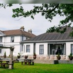 Manor Park Country House in Clydach, a white Italianate mansion with a terrace laid out for a wedding ceremony