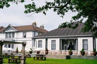 Manor Park Country House in Clydach, a white Italianate mansion with a terrace laid out for a wedding ceremony