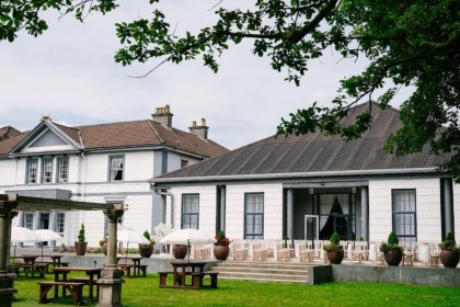 Manor Park Country House in Clydach, a white Italianate mansion with a terrace laid out for a wedding ceremony