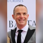 Martin Lewis, founder of MoneySavingExpert, smiling in a grey suit and black tie
