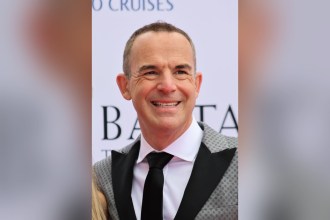 Martin Lewis, founder of MoneySavingExpert, smiling in a grey suit and black tie