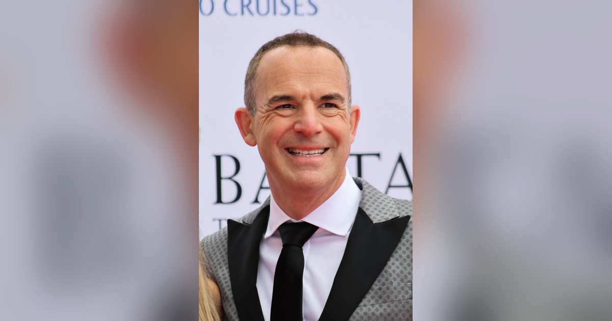 Martin Lewis, founder of MoneySavingExpert, smiling in a grey suit and black tie