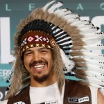 Swansea heavyweight Moses Jolly wearing a feathered headdress and an 'I am Native' waistcoat at a fight-week event