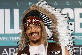 Swansea heavyweight Moses Jolly wearing a feathered headdress and an 'I am Native' waistcoat at a fight-week event