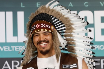 Swansea heavyweight Moses Jolly wearing a feathered headdress and an 'I am Native' waistcoat at a fight-week event