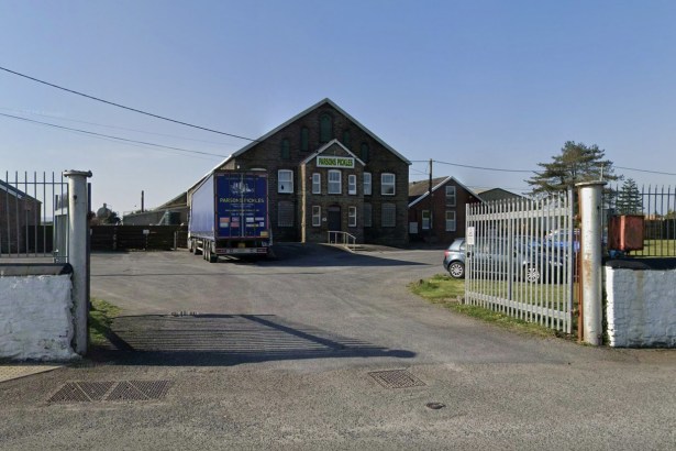 The entrance to Parsons Pickles at Burry Port, with a branded lorry parked outside the stone-fronted Ashburnham Works and palisade gates open onto the yard.