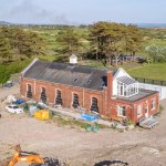 The Old Pump House at Pembrey seen from the air with a digger on cleared ground in front of it