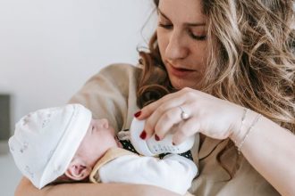 mother bottle feeding infant baby