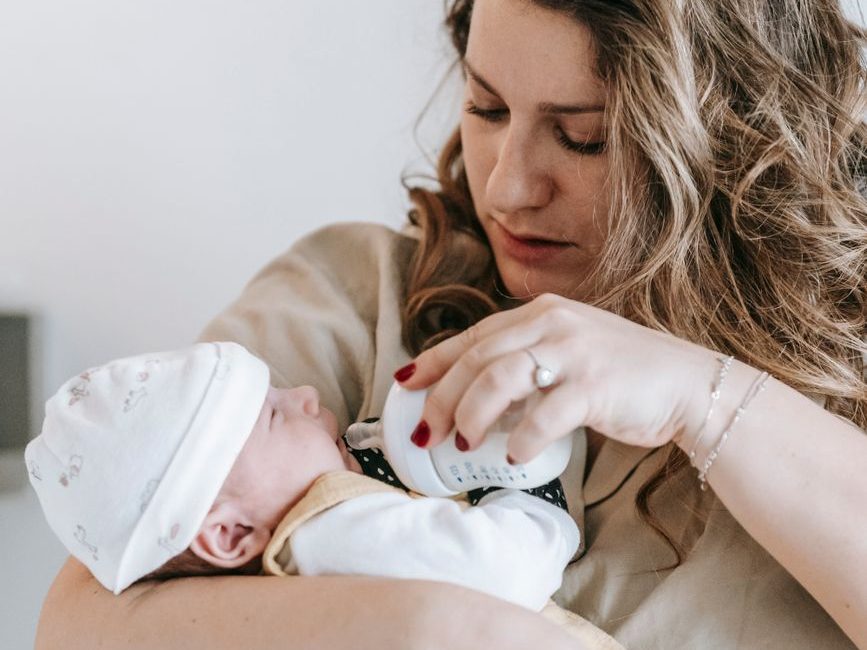 mother bottle feeding infant baby