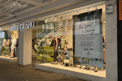 River Island's Oxford Street window in Swansea with a This Store is Closing poster, sale placards and mannequins