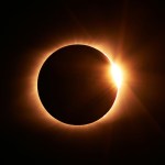 A total solar eclipse with the sun's corona blazing around the dark disc of the moon