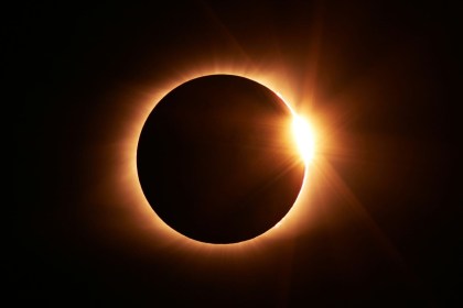 A total solar eclipse with the sun's corona blazing around the dark disc of the moon