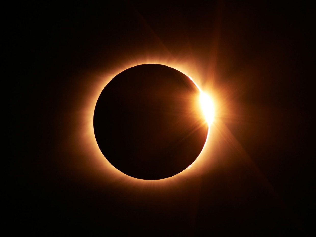 A total solar eclipse with the sun's corona blazing around the dark disc of the moon