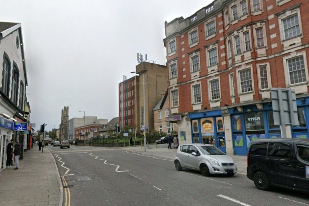 A Street View image of St Helen's Road in Swansea, with the YMCA building on the right and shops lining the street