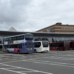 Buses lined up at Swansea bus station with the former Debenhams building behind