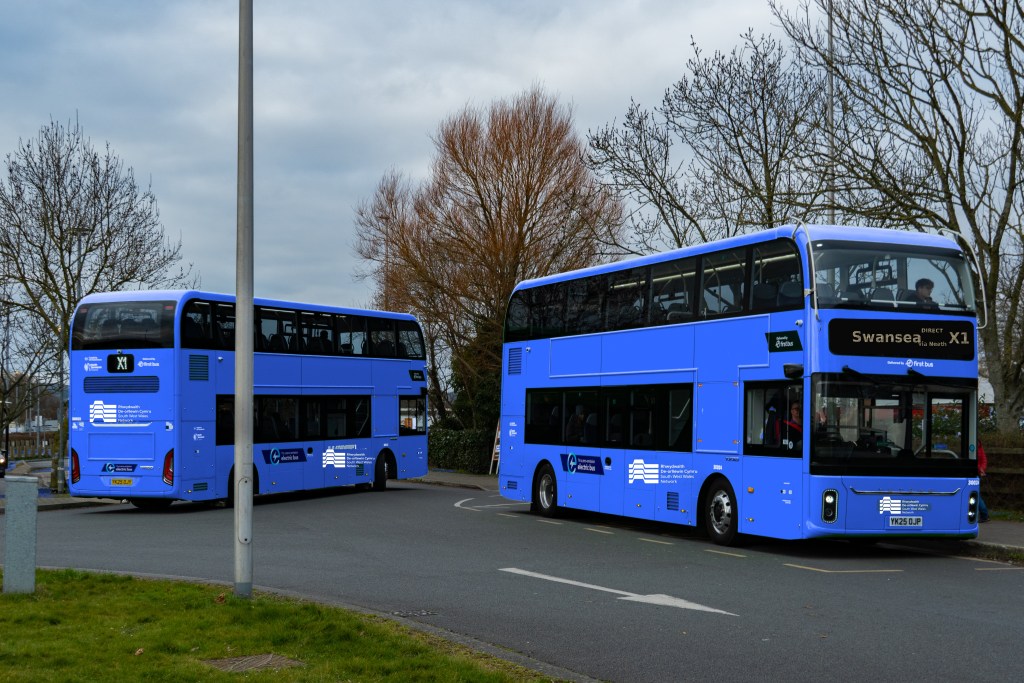 Two double-decker buses in blue South West Wales Network livery, a Swansea Bay News mock-up