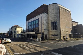 The former Odeon cinema building in Llanelli with its curved Art Deco corner tower, seen from the street in daylight
