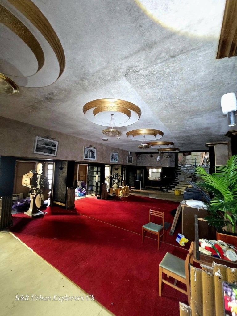 The cinema foyer with circular Art Deco ceiling details, red carpet and a kiosk counter