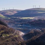 The Upper Afan Valley with a village and viaduct in the valley floor, wind turbines on the hilltops above