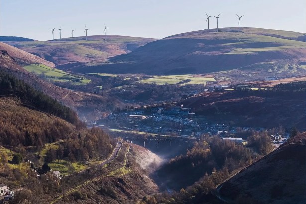 The Upper Afan Valley with a village and viaduct in the valley floor, wind turbines on the hilltops above