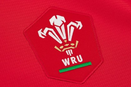 Close-up of the red WRU crest with the Prince of Wales feathers on the new red home jersey