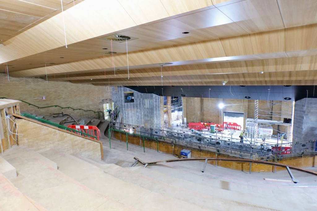 The timber ceiling over Yr Aelwyd's upper seating tiers with cables hanging ready for fittings