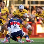 Dragons number eight Harri Keddie is tackled by Scarlets centre Gabe McDonald during the pre-season game at Llandovery