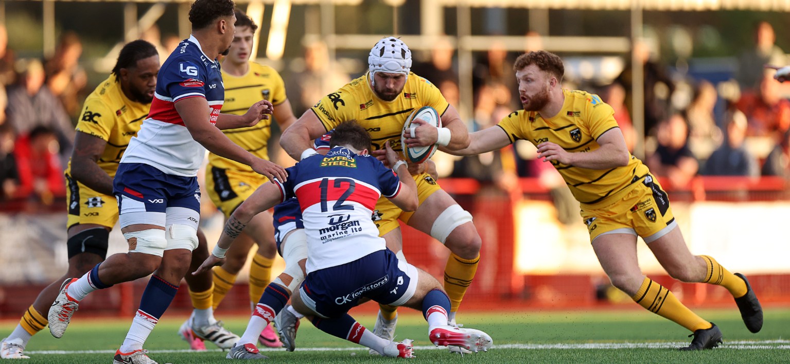 Dragons number eight Harri Keddie is tackled by Scarlets centre Gabe McDonald during the pre-season game at Llandovery