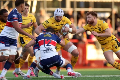 Dragons number eight Harri Keddie is tackled by Scarlets centre Gabe McDonald during the pre-season game at Llandovery