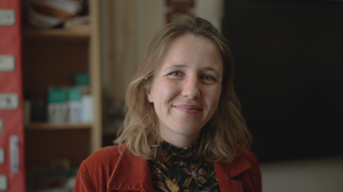 Jeanne Audren de Kerdrel, French and Spanish teacher at Ysgol Gymraeg Ystalyfera Bro Dur, smiling in a classroom in the S4C series Athrawon