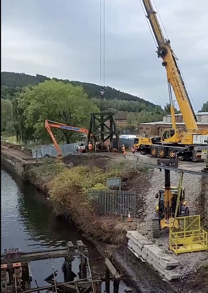 Wide view of the Bascule Bridge site with a trestle hanging from the crane and plant on the bank